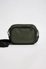 Bandolera verde militar con correa ancha negra ajustable.