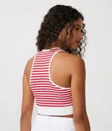 Musculosa cropped de punto acanalado con rayas horizontales rojas y blancas, cuello redondo y sisas con ribete blanco.