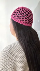 Gorro de crochet rosado con diseño de red.