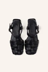 Sandalias franciscanas rojas de cuero con tiras entretejidas y hebilla lateral.