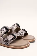 Sandalias marrones de cuero vacuno con doble tira y hebillas metálicas ajustables.