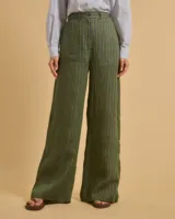 Pantalón de lino verde con rayas verticales negras y blancas, de tiro alto, corte palazzo y bolsillos laterales.