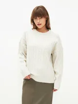 Sweater tejido con trenzas color beige claro, de corte holgado y cuello en V.
