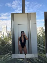 Malla enteriza negra con escote halter profundo y espalda descubierta.