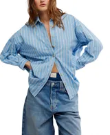 Camisa celeste a rayas verticales blancas, de corte oversize y estilo masculino, con cuello camisero, cierre frontal con botones y canesú en la espalda.