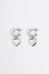 Aros de metal plateado con forma de aro y dije de corazón transparente facetado.