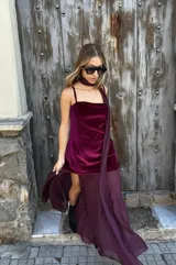 Vestido corto de terciopelo bordó con falda asimétrica y capa de gasa a juego.