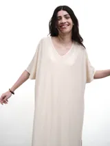 Vestido largo color crema con escote en V y mangas cortas amplias. Tejido con lurex.