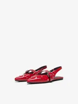 Ballerinas rojas de cuero sintético con puntera fina, tira sobre el empeine con hebilla y tachas plateadas.