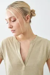 Remera color beige melange de corte clásico, con escote en V y mangas cortas con dobladillo.
