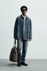 Sobrecamisa relaxed fit confeccionada en denim de algodón con efecto lavado. Tiene cuello solapa, manga larga, bolsillos frontales de plastrón y cierre frontal de botonadura.