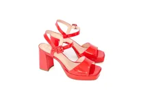 Sandalias rojas de charol con plataforma de 2 cm y taco de 10 cm. Diseño minimalista con tiras finas sin costuras y hebilla lateral.