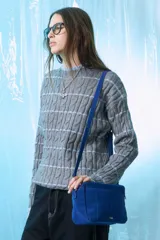 Sweater gris de tejido de ochos con rayas horizontales celestes.