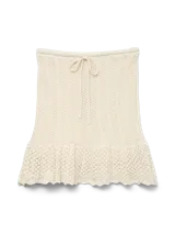 Falda tejida de algodón color crudo, con cintura elastizada con cordón ajustable y volado en el ruedo.