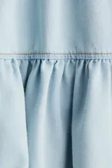 Minifalda celeste de denim con cintura elastizada y volados en el ruedo.