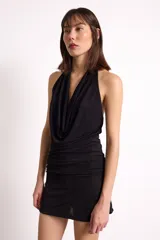Minivestido negro con escote drapeado tipo cowl neck, corte ajustado y espalda descubierta.