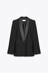Blazer negra de corte clásico con cuello smoking de satén, manga larga con hombreras, bolsillos con solapa y cierre frontal con botón.