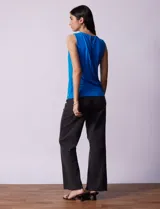 Blusa sin mangas color amarillo, con cuello redondo con frunces delanteros y abertura con botón en la espalda.
