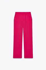 Pantalón de tiro alto color fucsia, con bolsillos delanteros y falsos bolsillos de vivo en la espalda. Tejido con efecto arrugado, pernera recta y cierre frontal con cremallera, botón interior y gancho.