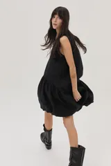 Vestido corto negro de lino, corte evasé, sin mangas y con escote redondo.