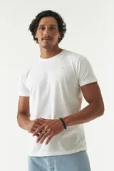 Remera color salmón de corte clásico, cuello redondo y logo bordado en el pecho.