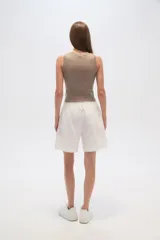 Short de lino color blanco, de calce alto y con bolsillos laterales.