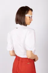 Blusa color naranja con manga princesa, nudo inferior y corte ajustado, confeccionada en 100% algodón.