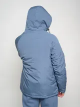 Campera corta de abrigo Umbro Crafted Pro, color negro con paneles laterales en gris. Presenta capucha con cordón ajustable, cierre frontal completo y logo de la marca bordado en el pecho.