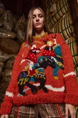 Sweater tejido y bordado a mano de lana color ladrillo, de calce holgado, con cuello a la base y puños. Presenta bordados de figuras humanas y animales.