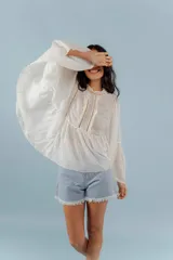 Camisa azul de algodón con cuello alto y mangas largas acampanadas con detalles de puntilla.