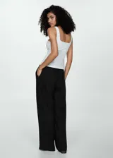 Pantalón de lino blanco, de corte recto, con cintura elástica y lazo de ajuste.