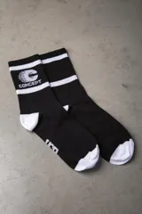 Medias negras con puntera y talón blancos, dos rayas horizontales blancas en la parte superior y logo de la marca en blanco.