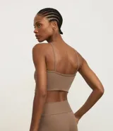 Top deportivo color marrón topo, ajustado al cuerpo, con escote halter cruzado y tirantes finos.