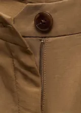 Pantalón de tiro medio color marrón, con trabillas, cierre delantero con cremallera y botón, dos bolsillos laterales, pinzas delanteras y diseño recto con aberturas en el bajo.