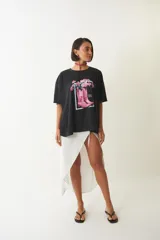 Remera negra de corte amplio con estampa de botas de cowboy rosas y flores.