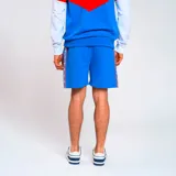 Bermuda deportiva azul con cintura elástica y cordón ajustable. Presenta una banda lateral con diseño geométrico en blanco, rojo y azul. Incluye el logo del club deportivo en la pierna izquierda.