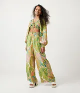 Blusa cropped de viscosa con estampado tropical de follaje, escote en V con lazo, mangas largas con elástico y bajo ajustable.