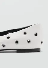 Zapato tipo ballerina color blanco con perforaciones circulares y punta redonda.