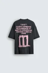 Camiseta negra de corte holgado con cuello redondo y mangas cortas. Estampado frontal y trasero con textos y figuras en color rosa.