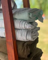 Pantalón de vestir verde a rayas verticales blancas, con bolsillos laterales y traseros.