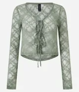 Blusa verde de encaje floral transparente, con escote en V y lazos delanteros.