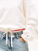 Buzo cropped con capucha color blanco, de corte holgado y mangas largas con puños elásticos.