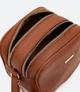 Bolso bandolera pequeño de cuero sintético negro con doble compartimento con cierre de cremallera dorada, asa corta y correa larga ajustable. Incluye pompón decorativo.