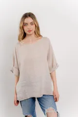 Blusa color beige confeccionada en lino, de corte holgado, mangas 3/4 y cuello redondo.