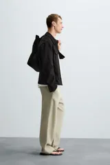 Sobrecamisa color beige de tejido efecto ante, corte regular fit, con cuello solapa, manga larga con puños abotonados, bolsillos de parche con solapa en el pecho y bolsillos de ojal en la cadera.