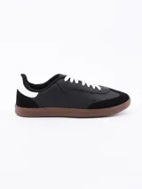 Zapatillas deportivas blancas con puntera de gamuza gris, talón negro y suela marrón.