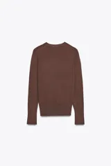 Sweater negro de punto liso con cuello redondo y mangas largas con botones dorados en los puños.