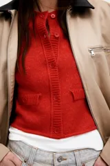 Cárdigan rojo de punto suave con cuello polo acanalado, cierre frontal con botones, mangas cortas y bolsillos delanteros decorativos con botón.