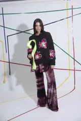 Sweater tejido y bordado a mano en lana merino, color marrón oscuro, con cuello redondo y puños ajustados. Presenta bordados florales multicolores en el frente y las mangas.