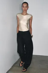 Camiseta dorada de cuello redondo y manga corta, con tejido metalizado.